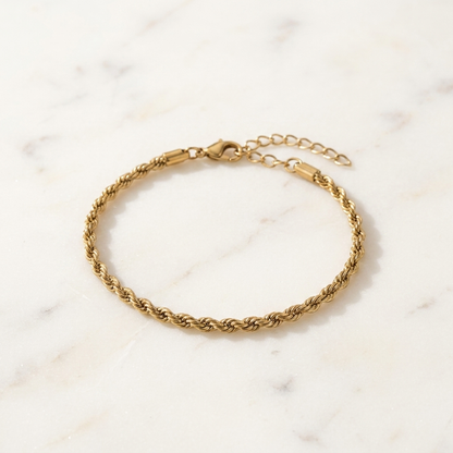 Gold-toned Signature Rope Chain Bracelet laid in a soft curve on a bright premium surface