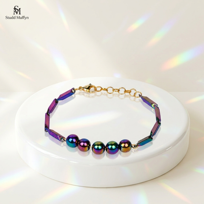 Prism Hematite Rice Chain Bracelet draped over a white pedestal on a bright premium set