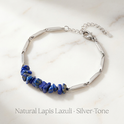 Lapis lazuli crystal silver rice chain bracelet laid on a soft neutral surface