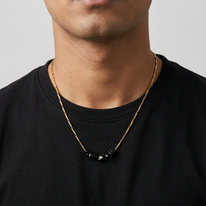 Man wearing the gold-tone Obsidian rice chain necklace with a plain black tee