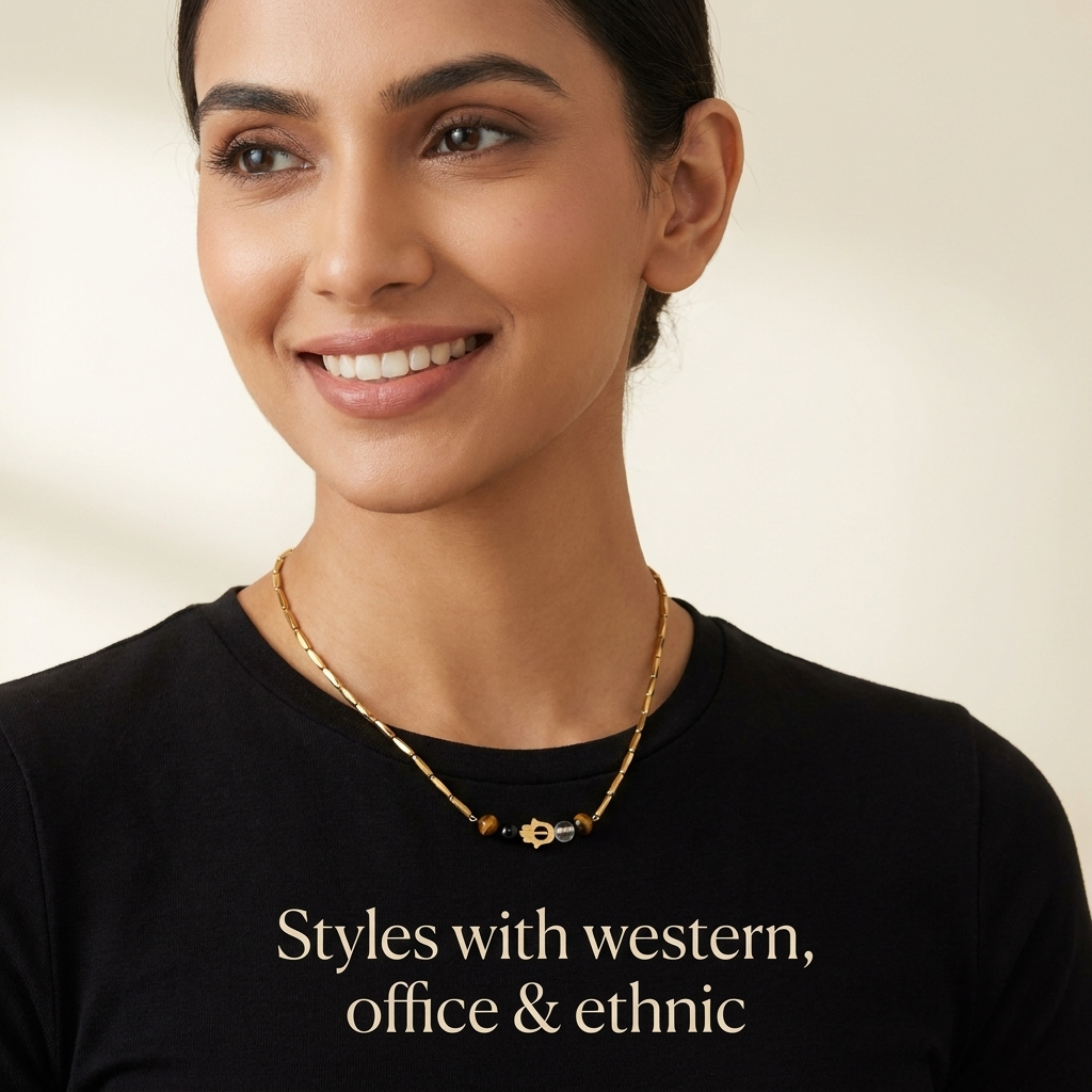 Woman styling the golden Hamsa crystal rice chain necklace with a neutral outfit
