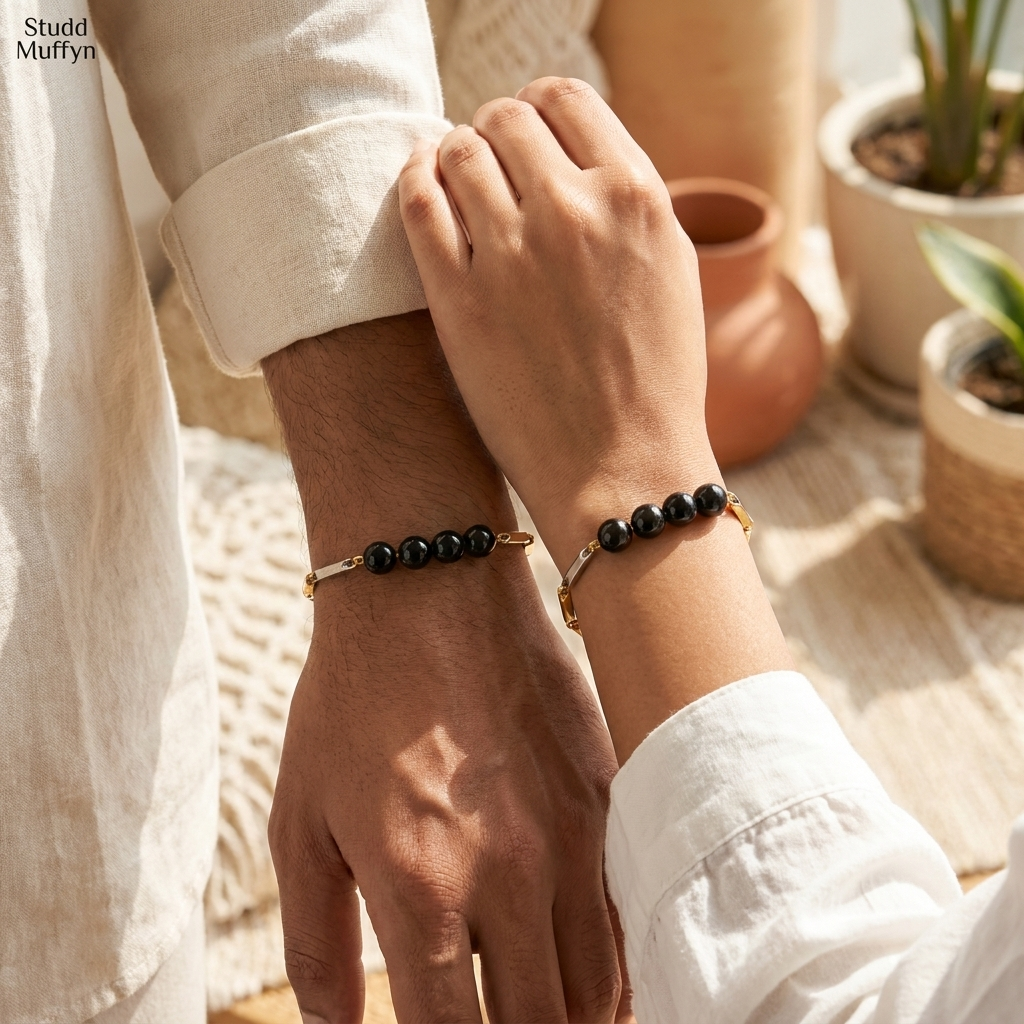 A man and a woman both wearing the unisex Black Obsidian dual-tone bracelet on their wrists in a bright airy setting