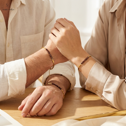 A man and a woman wearing the Passion Golden Rice Bracelet on their wrists